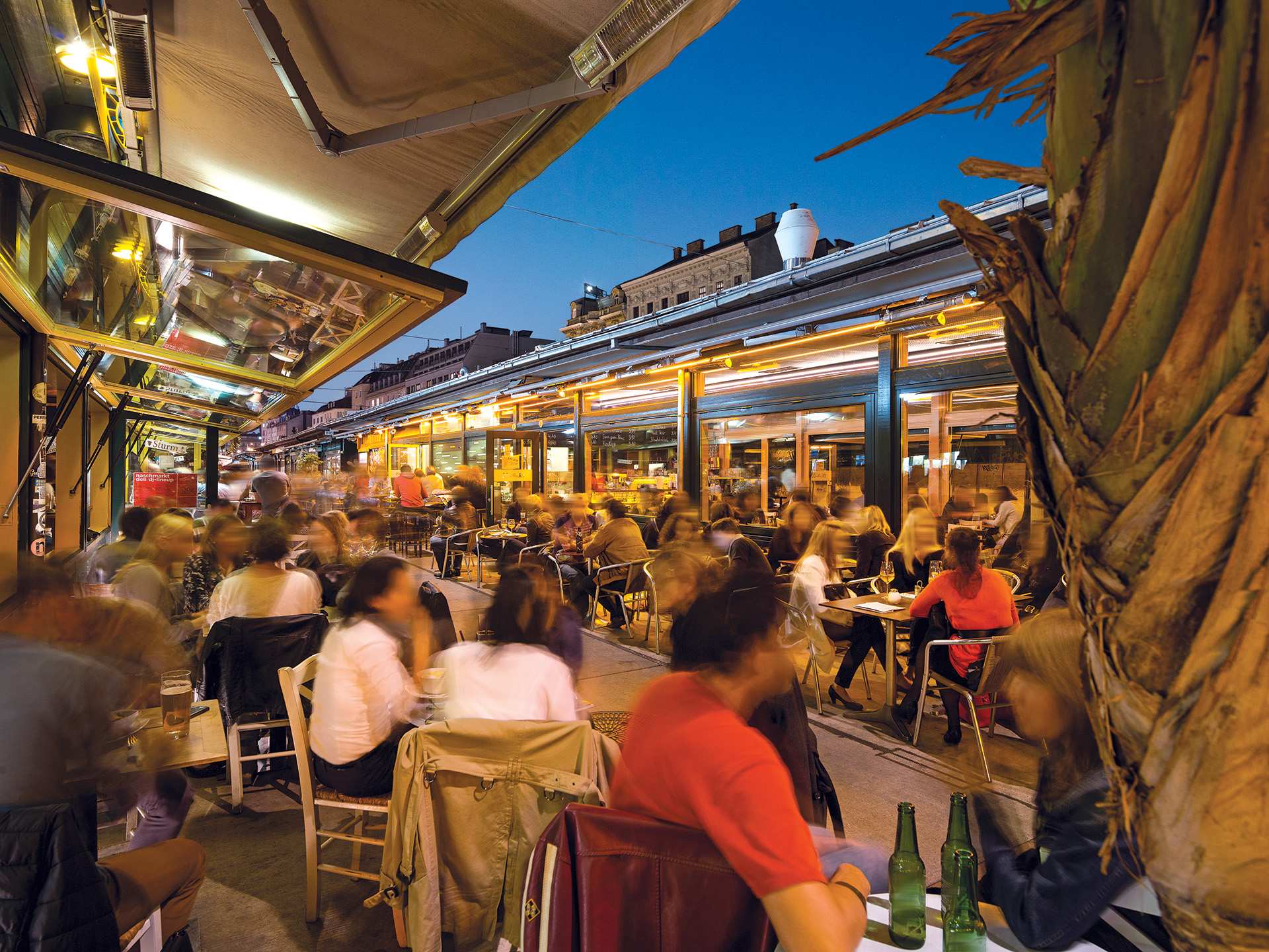 People enjoying food and drink at Naschmarkt in Vienna