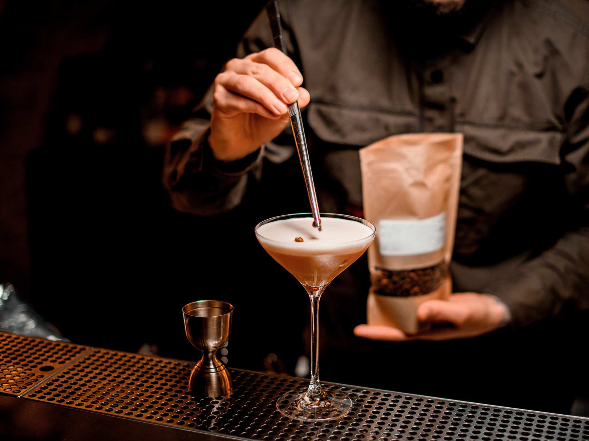 A bartender garnishing an espresso martini