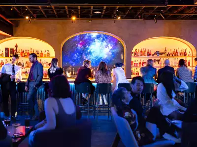 Happy hours Toronto | Guests sitting at the glowing bar at Offworld for Happy Hour