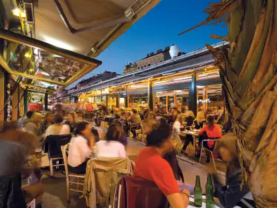 People enjoying food and drink at Naschmarkt in Vienna