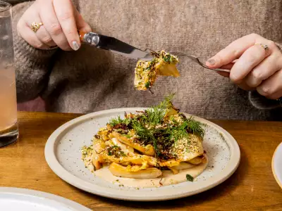 Romantic Restaurants | A hand uses a knife and fork at The Rosebud