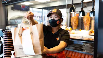 The best new restaurants in Toronto | Staff hand a takeout order over the counter at German Doner Kebab