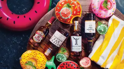 Summer drinks | Whisky bottles on a wood raft surrounded by floaties