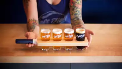 Toronto bottle shops and alcohol stores | A person holding a flight of three beers at Left Field Brewery in Toronto
