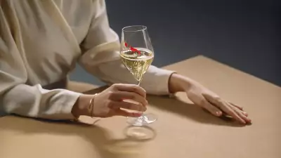 GH Mumm | A woman in a cream coloured blouse holds a glass of GH Mumm champagne