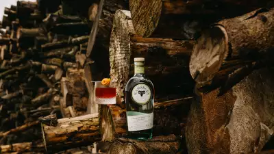 Ramsbury Gin Fall | The Chestnut Bramble sits on a log with a bottle of Ramsbury Gin