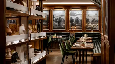 REIGN Toronto | Elegant dining room at Reign Toronto with green velvet seating, rich wood accents and warm lighting