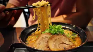 The best ramen in Toronto | Someone lifting noodles from a spicy red miso ramen at Ramen Isshin