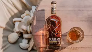 Bearface Matsutake whisky on a table next to mushrooms