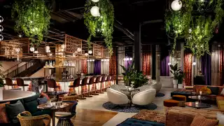 The stunning lounge area with plants, plush seating and a bar at Skylight Rooftop at W Toronto