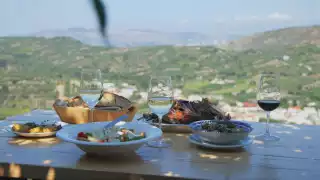 Greek wines | A table of food and wine overlooking Crete, Greece