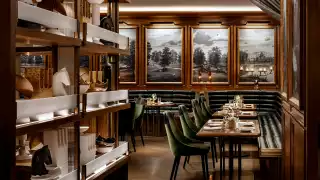 REIGN Toronto | Elegant dining room at Reign Toronto with green velvet seating, rich wood accents and warm lighting