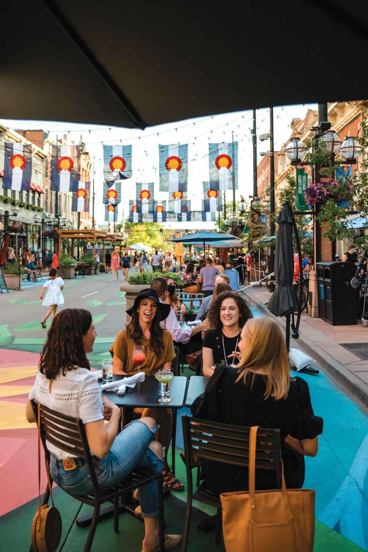 People sit on a patio in Larimer Square in Denver, Colorado People sit on a patio in Larimer Square in Denver, Colorado
