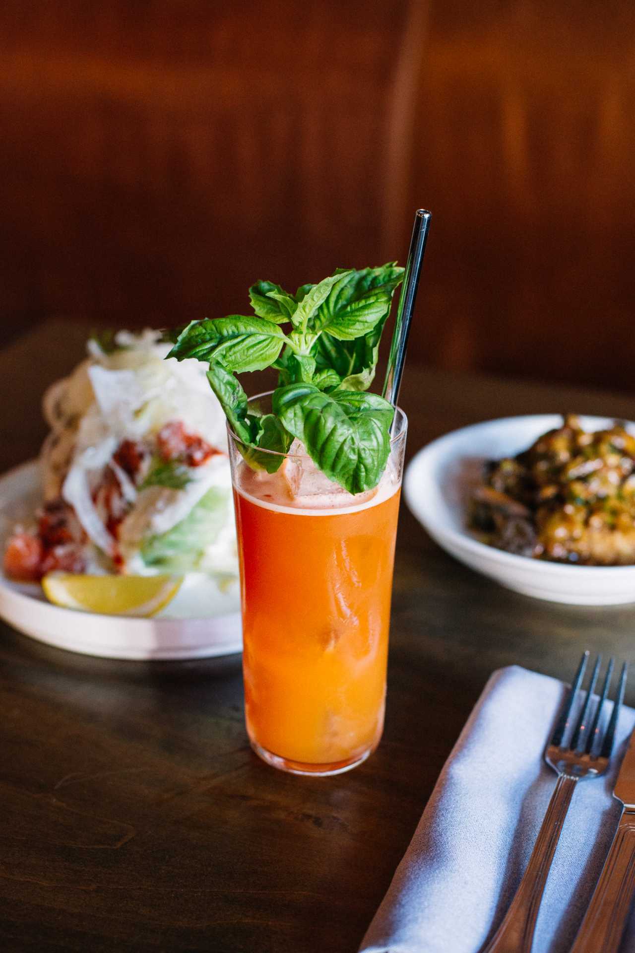Contrada restaurant in Toronto | Rosso Malpelo cocktail with plates of food Contrada restaurant in Toronto | Rosso Malpelo cocktail with plates of food