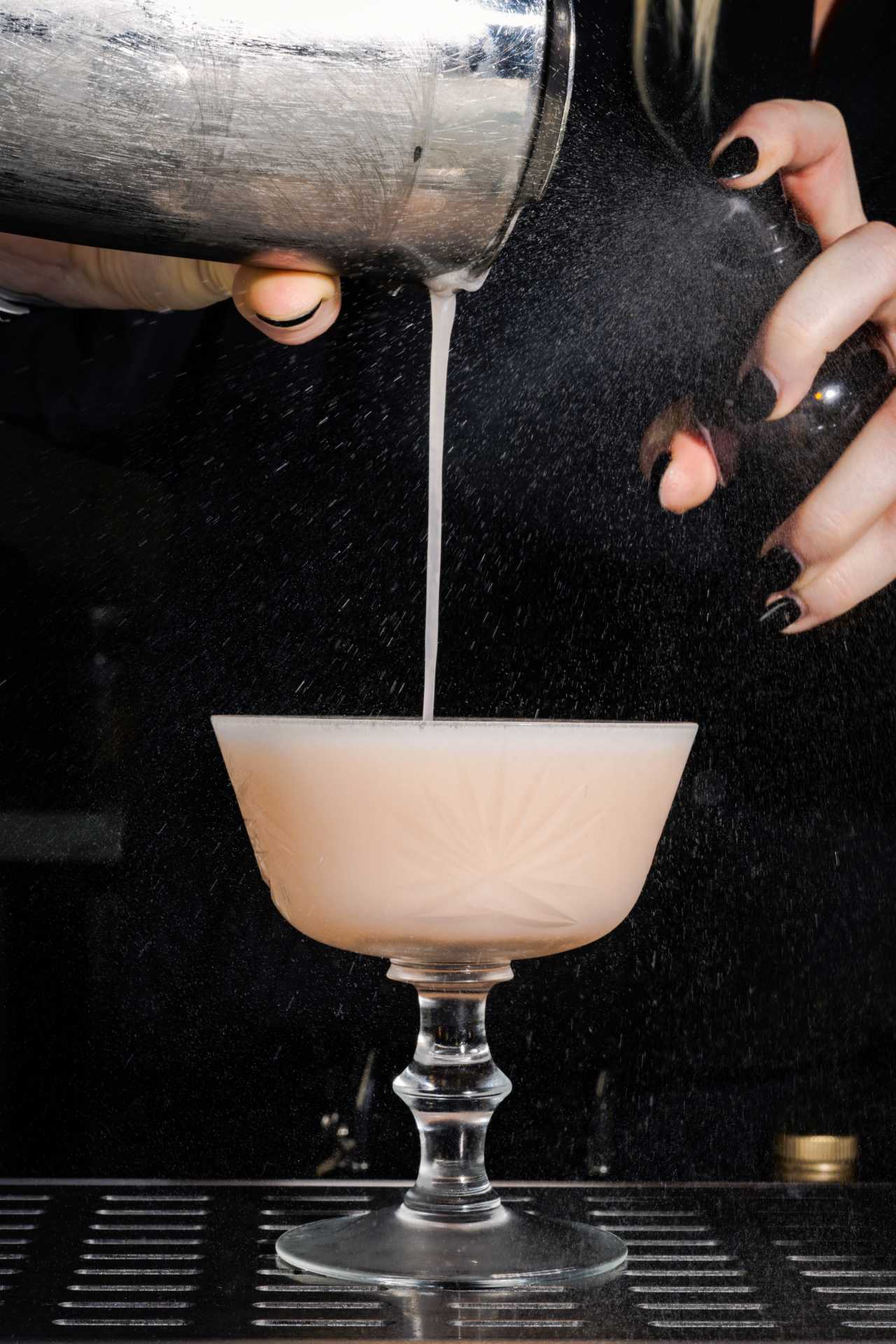 A bartender pours Aunt Spike, a peachy spin on a gin sour, at Lisbon Hotel A bartender pours Aunt Spike, a peachy spin on a gin sour, at Lisbon Hotel