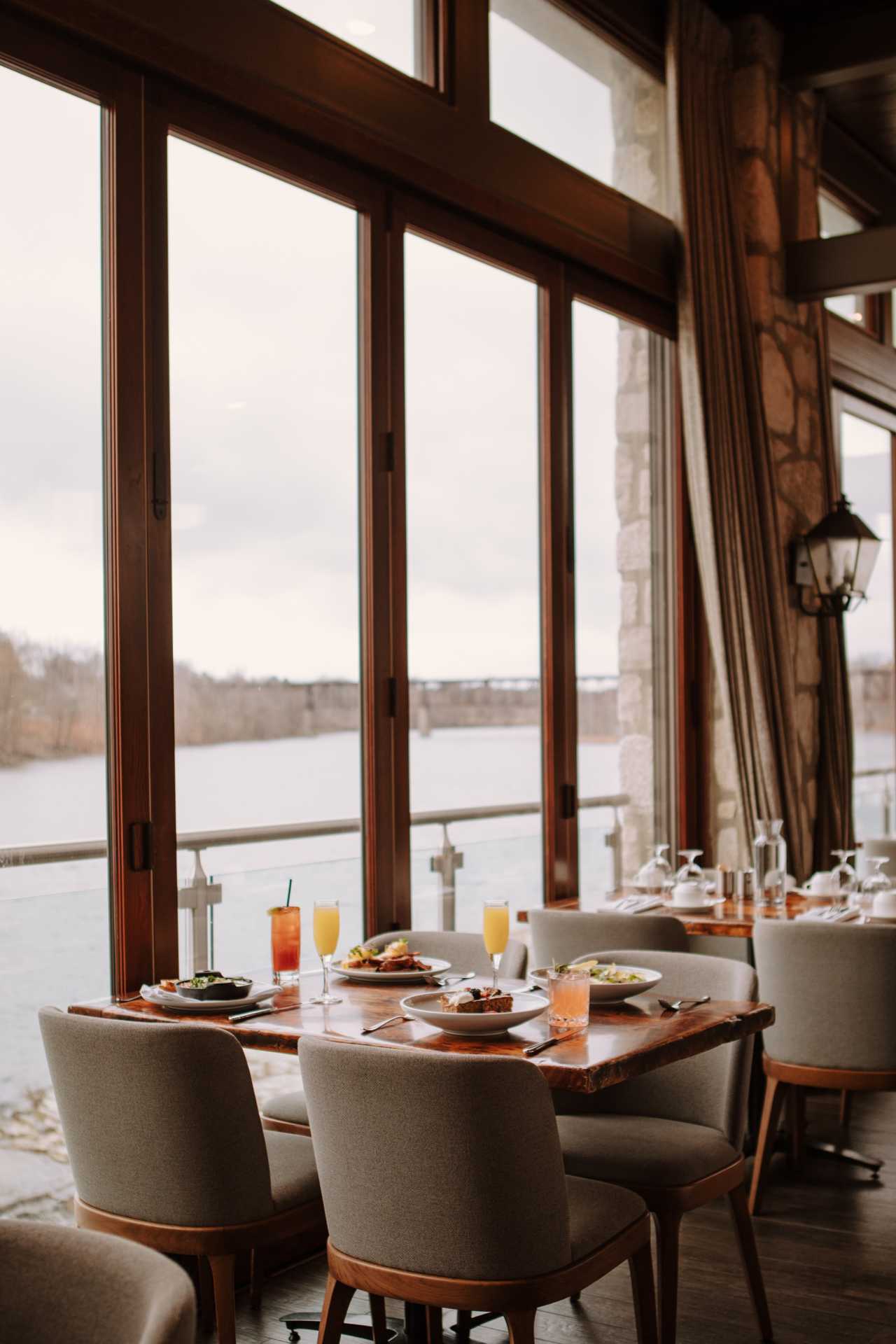 Cambridge Mill | A brunch spread on a table with a view of the Grand River Cambridge Mill | A brunch spread on a table with a view of the Grand River