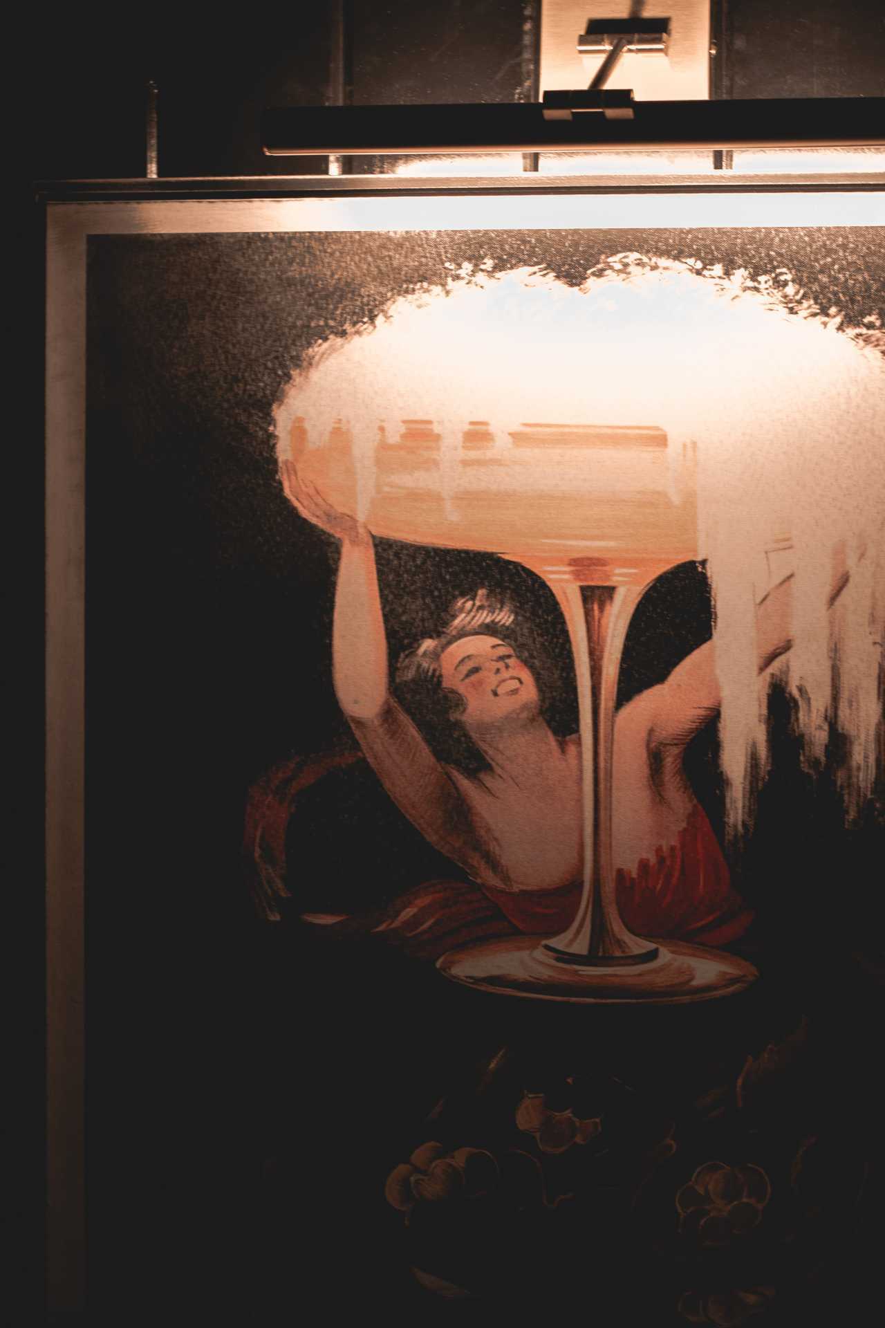 Cafe Renée, Toronto | A poster of a girl with a giant champagne glass at Cafe Renée