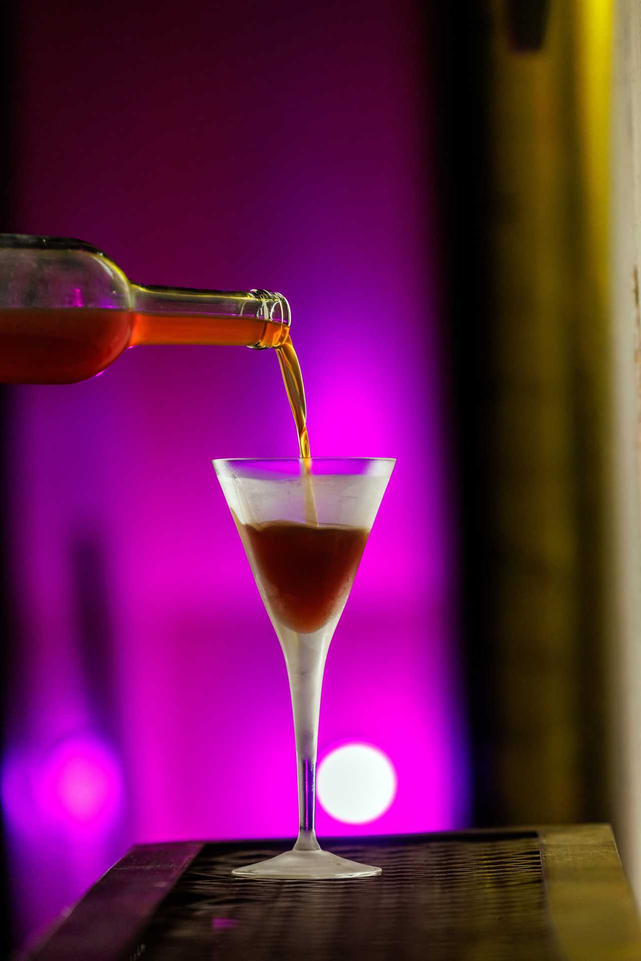 The best bars in Toronto | Pouring a cocktail into a martini glass at Cry Baby Gallery