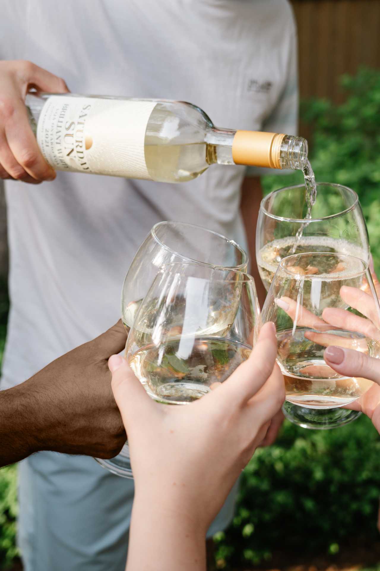 Pouring Saturday Sun Brilliant White Harvest VQA into friends' glasses
