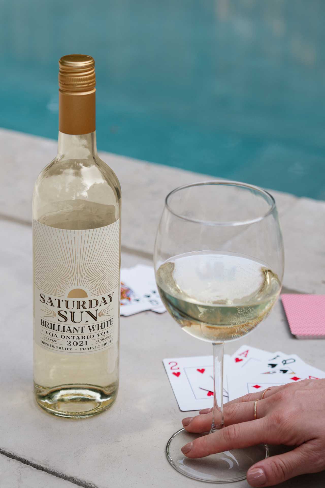 Saturday Sun Brilliant White Harvest VQA with playing cards beside a pool