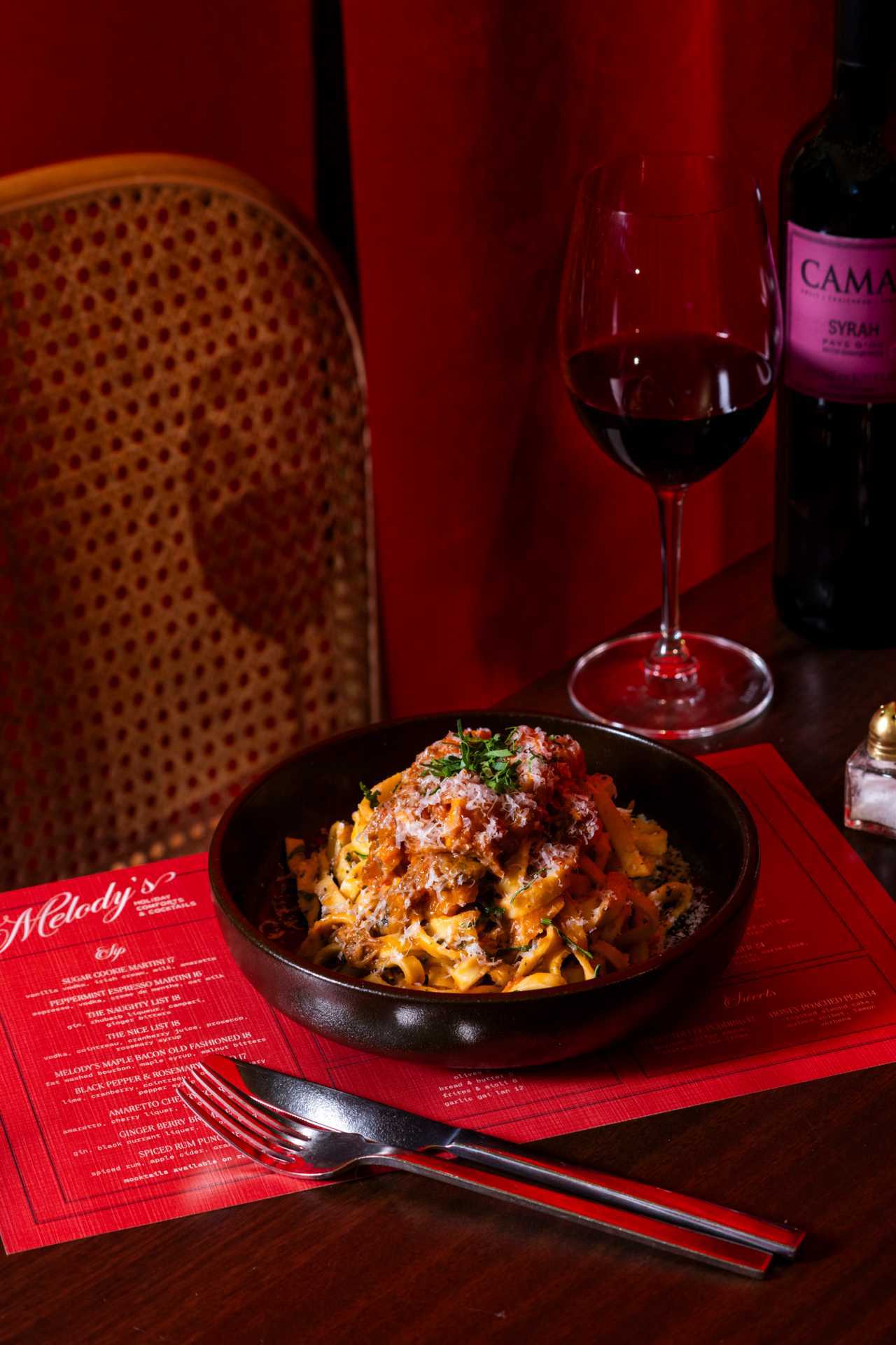 Best Christmas bars and markets in Toronto | A glass of red wine and a plate of pappardelle pasta at Melody's at Gladstone House