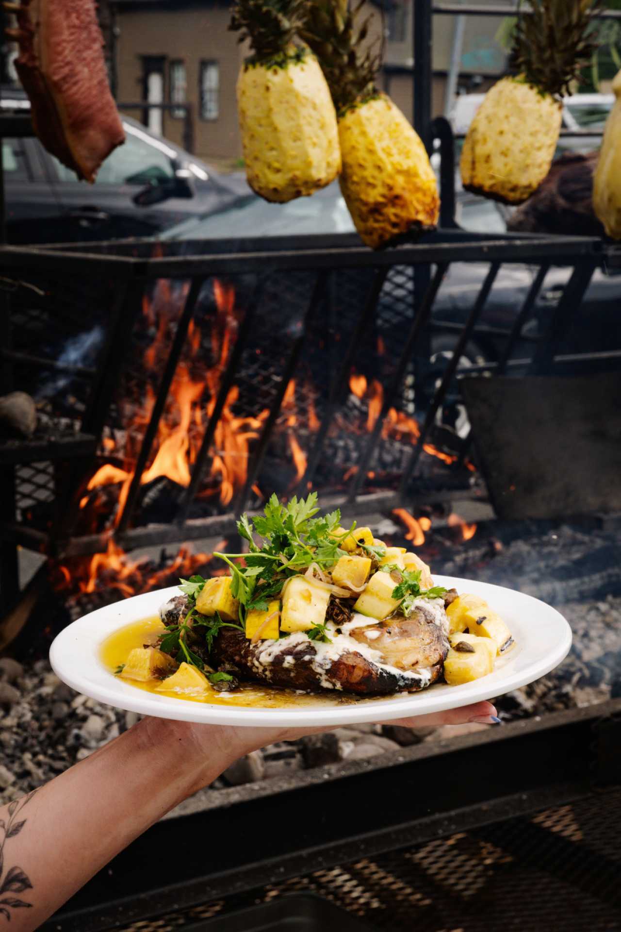 Fat Rabbit: A dish with roasted pineapple is held in front of a fire at Fat Rabbit