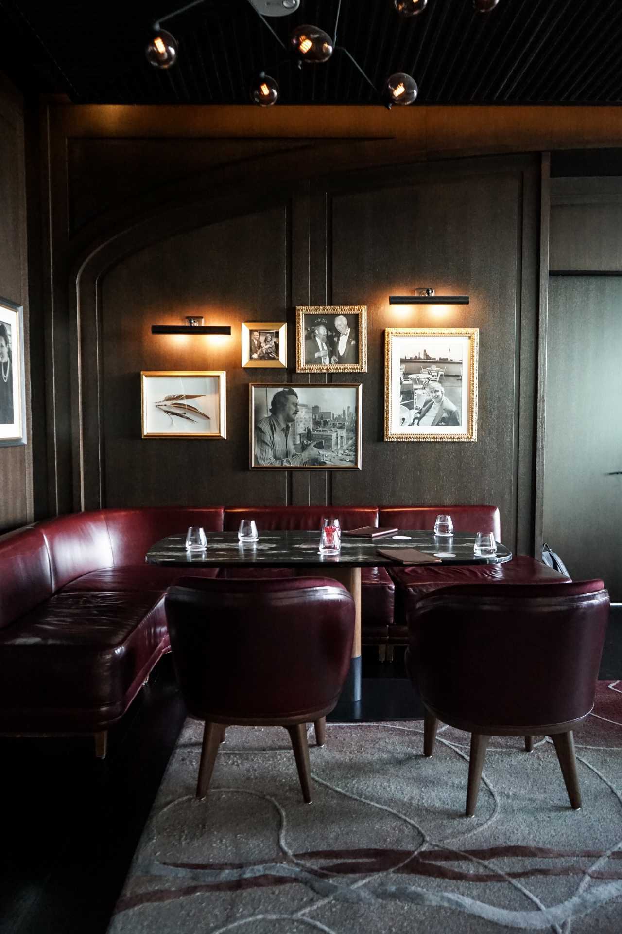 Photographs hang above a banquette at Writers Room Bar