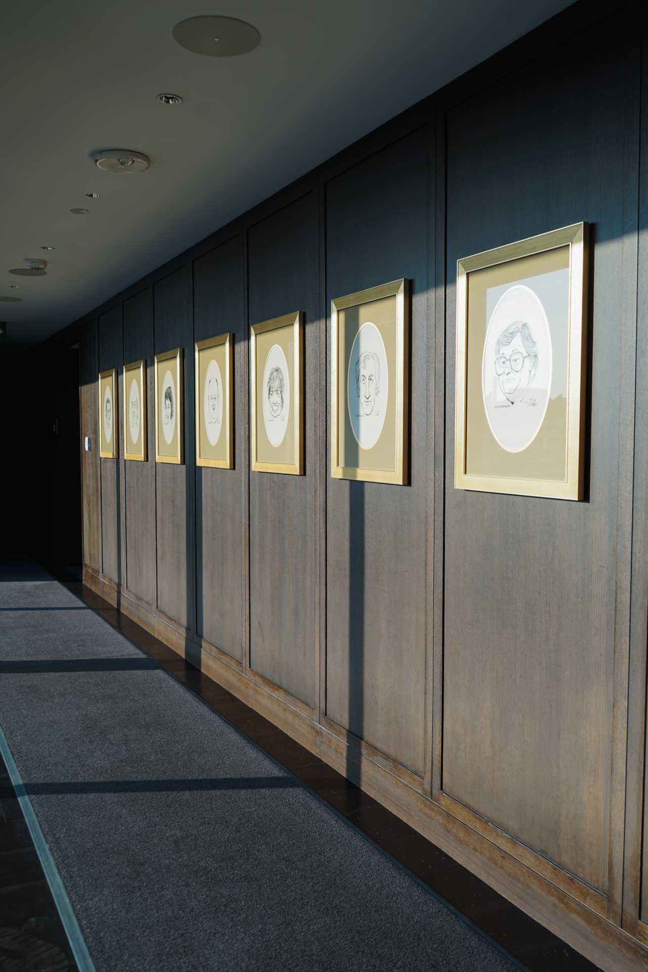 Caricatures of authors hang in the hall at Writers Room Bar Toronto