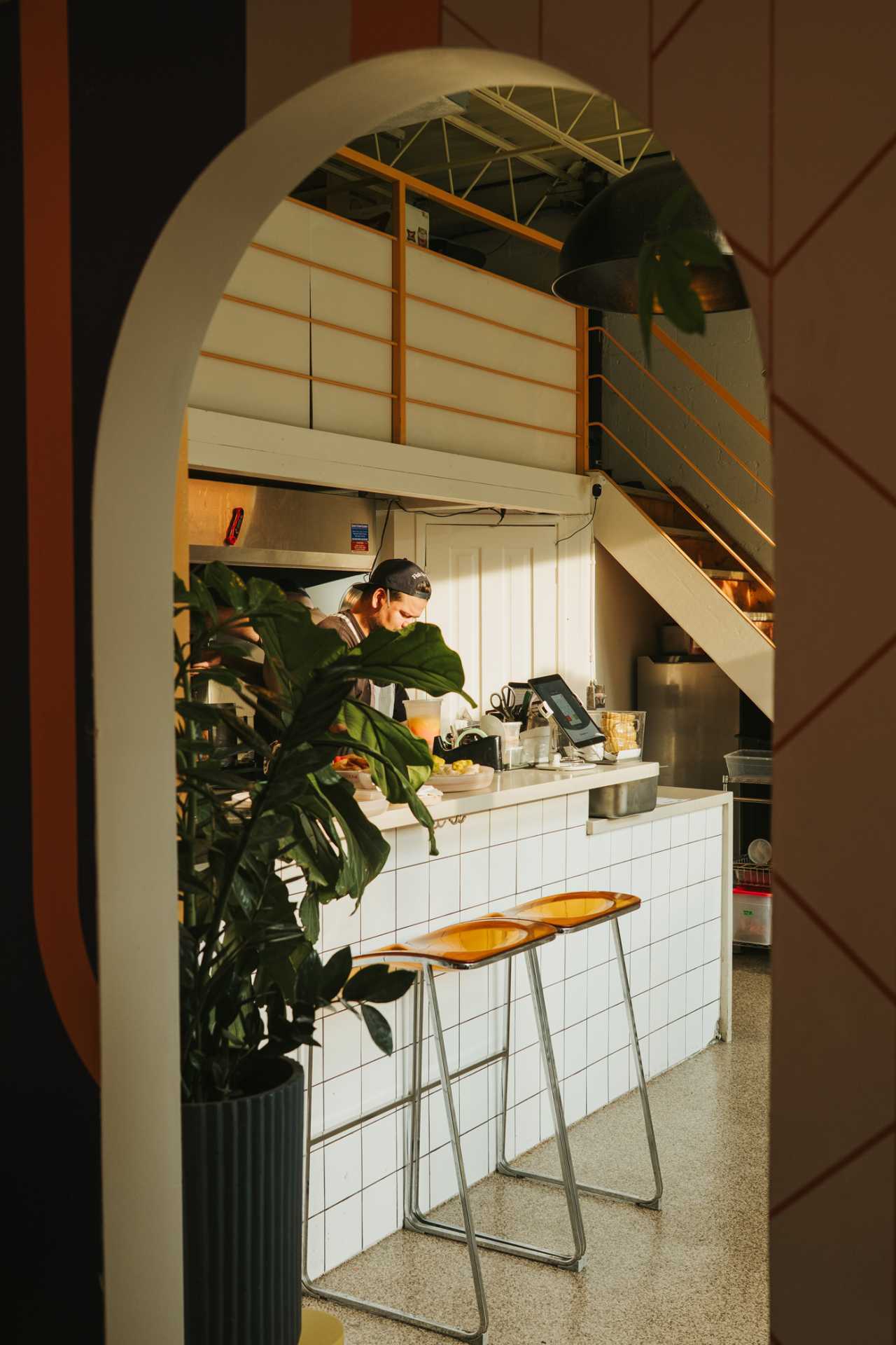 The best bars in Toronto | Looking through a doorway, a chef cooks at Simpl Things