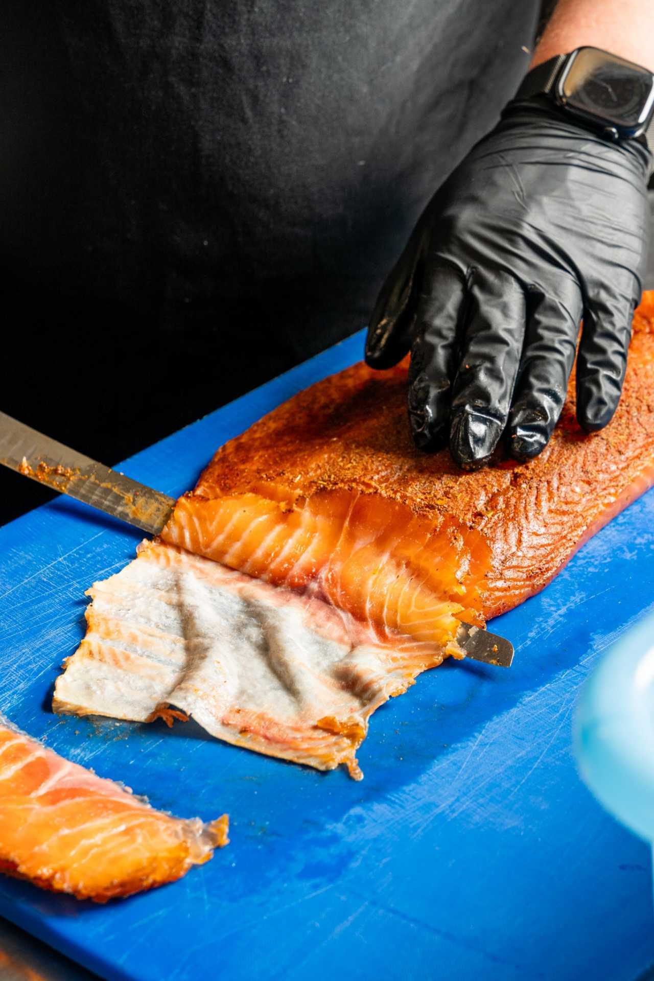 Farm-to-table dining in Qu&eacute;bec: A hand slices smoked salmon at Chez Greenberg
