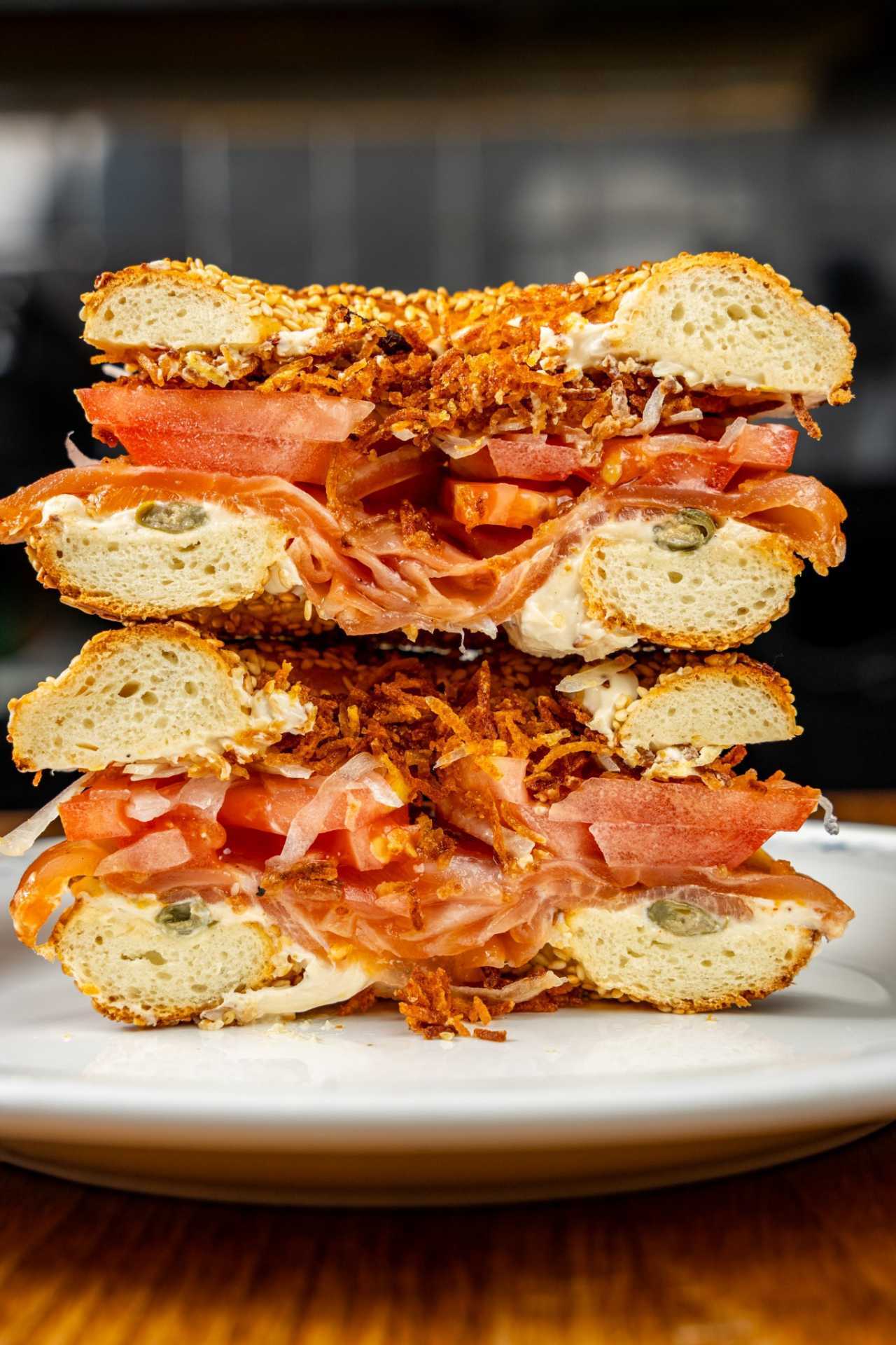 Farm-to-table dining in Qu&eacute;bec: A cross-section of a bagel filled with tomato, bacon and more at Chez Greenberg