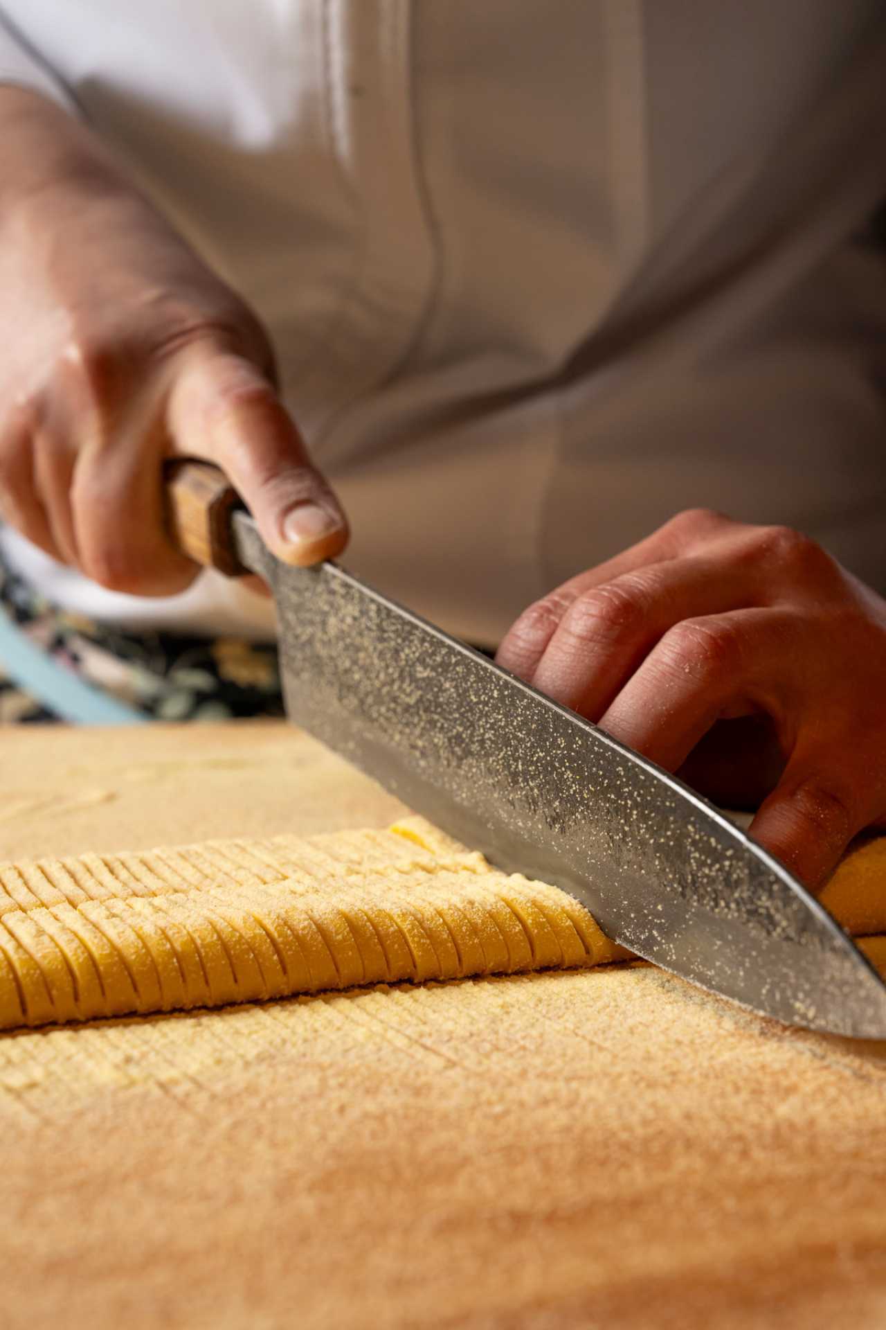 Pasta Privato Toronto | A hand with a chef's knife chops fresh pasta at Pasta Privato in Toronto