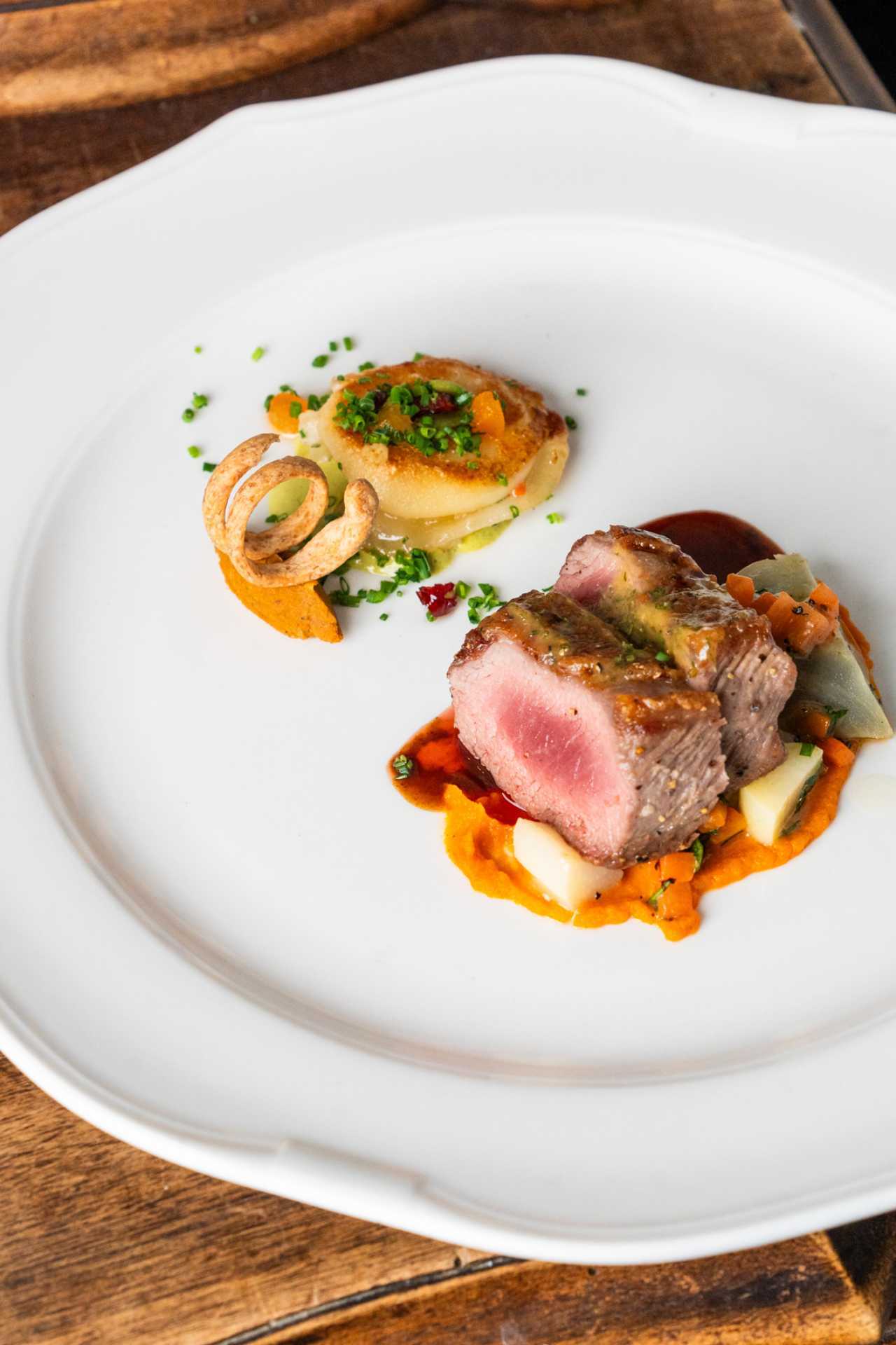 George Restaurant | Tenderloin with sweet potato purée, root vegetables, potato gâteau, crispy onion and red wine jus.