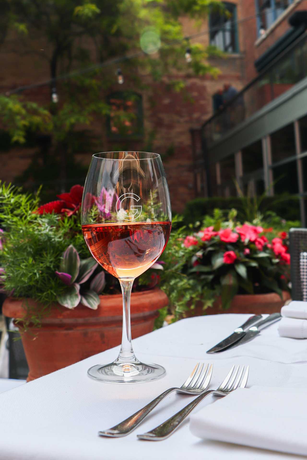 George Restaurant | A glass of wine is seen on a table in George Restaurant's courtyard patio
