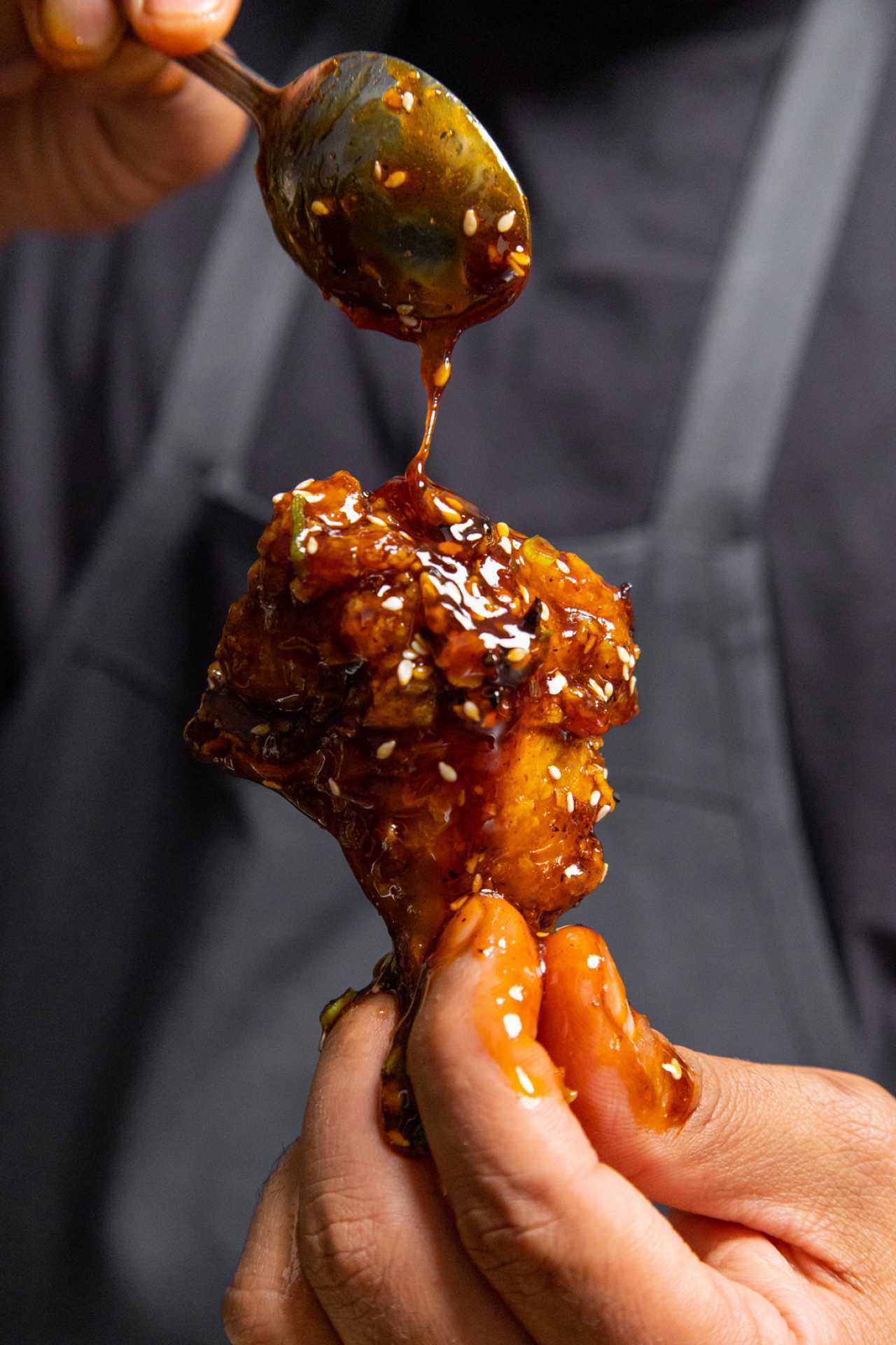Summerlicious Toronto | A hand holds a sticky dish on the menu at Curryish for Summerlicious Toronto