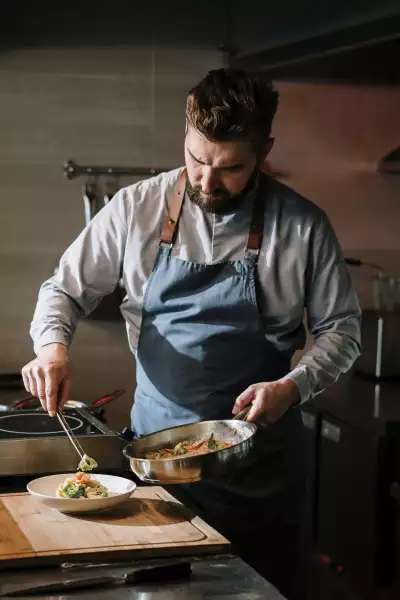 A chef wearing an apron plating a dish in Qu&eacute;bec