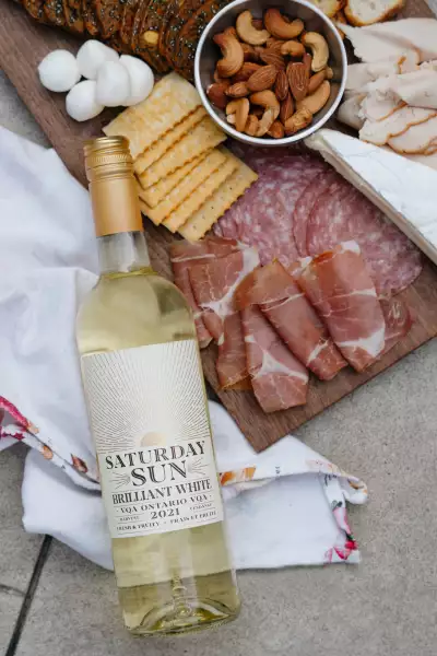 Saturday Sun Brilliant White Harvest VQA with a charcuterie board