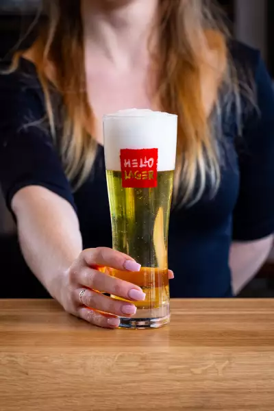 Hello Nori, King West, Toronto | A hand holds out a beer