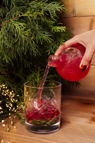 Christmas bars and markets in Toronto | Pouring a cocktail from a Christmas ornament at KŌST Chalet in Toronto