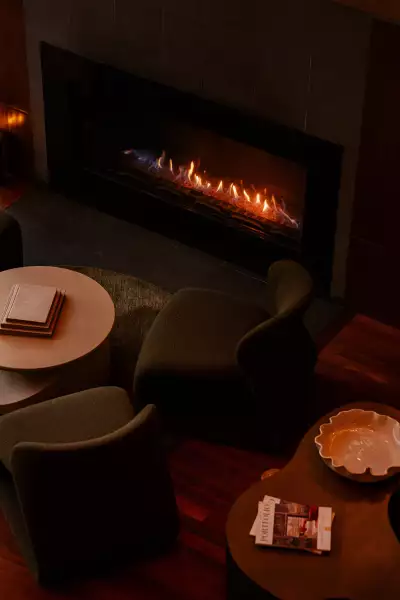 A couch and a fireplace inside Mercer Lounge in Le Germain Hotel Toronto Mercer