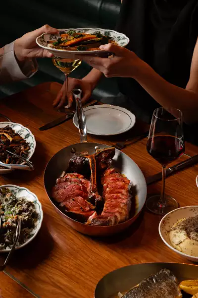 REIGN Toronto | Tomahawk and sides sit on a table at REIGN