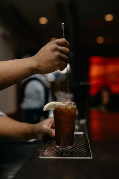 Takja BBQ | A bartender stirs a cocktail at Takja BBQ