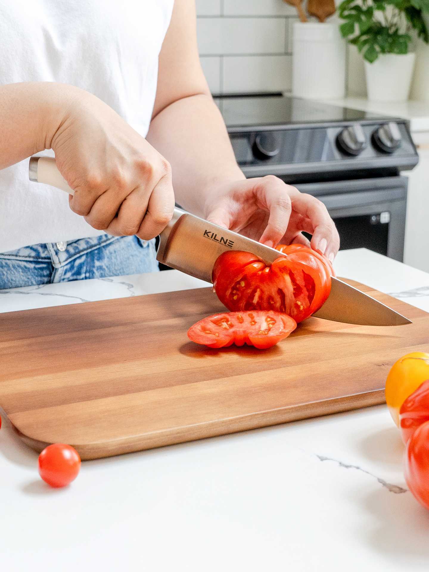 Kilne Ultimate Knife Set review | Person chopping a tomato on a cutting board with the Kilne Ultimate Knife Set chef's knife Kilne Ultimate Knife Set review | Person chopping a tomato on a cutting board with the Kilne Ultimate Knife Set chef's knife