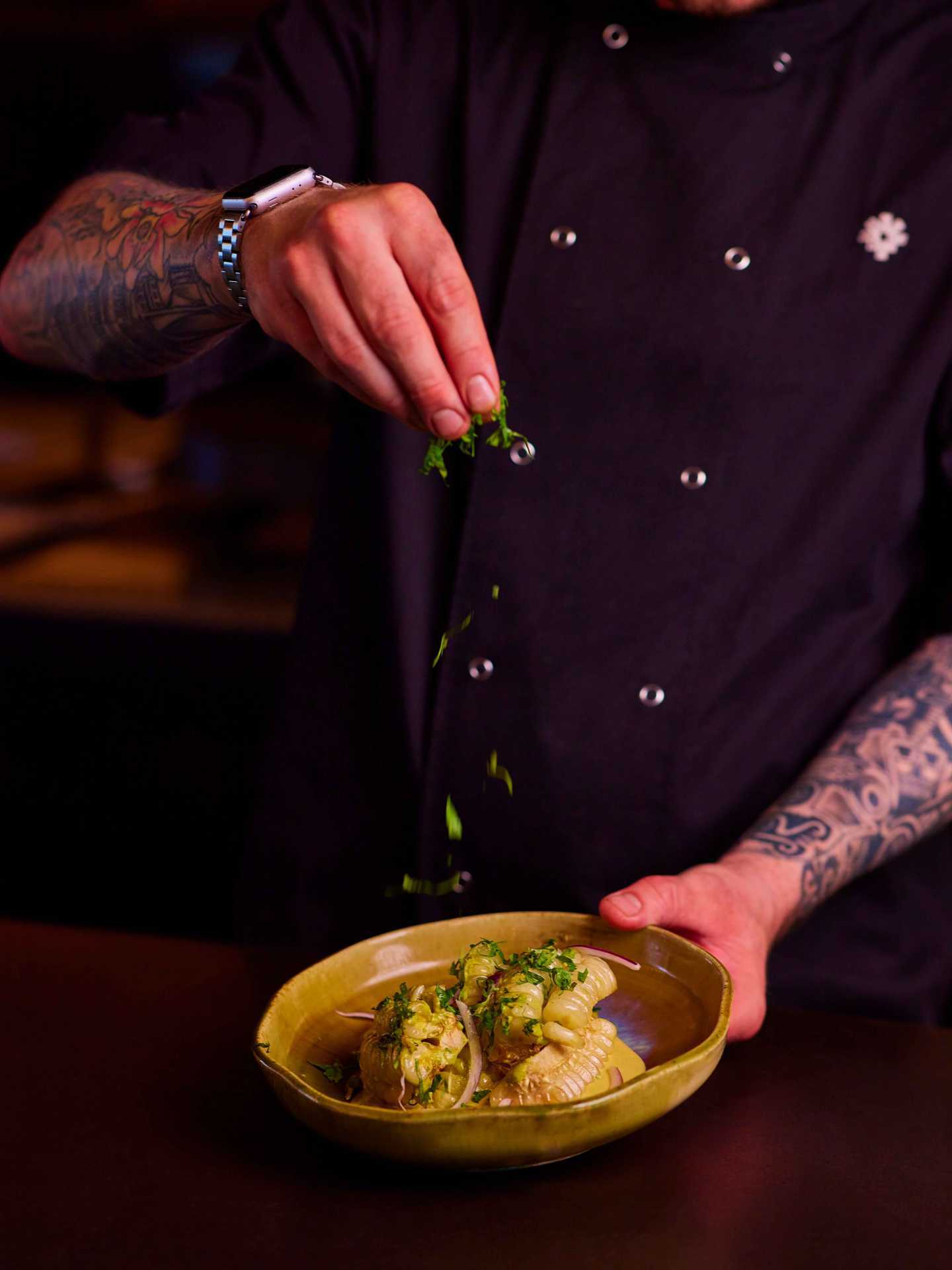 Best happy hours in Toronto | A chef holding a plate of food