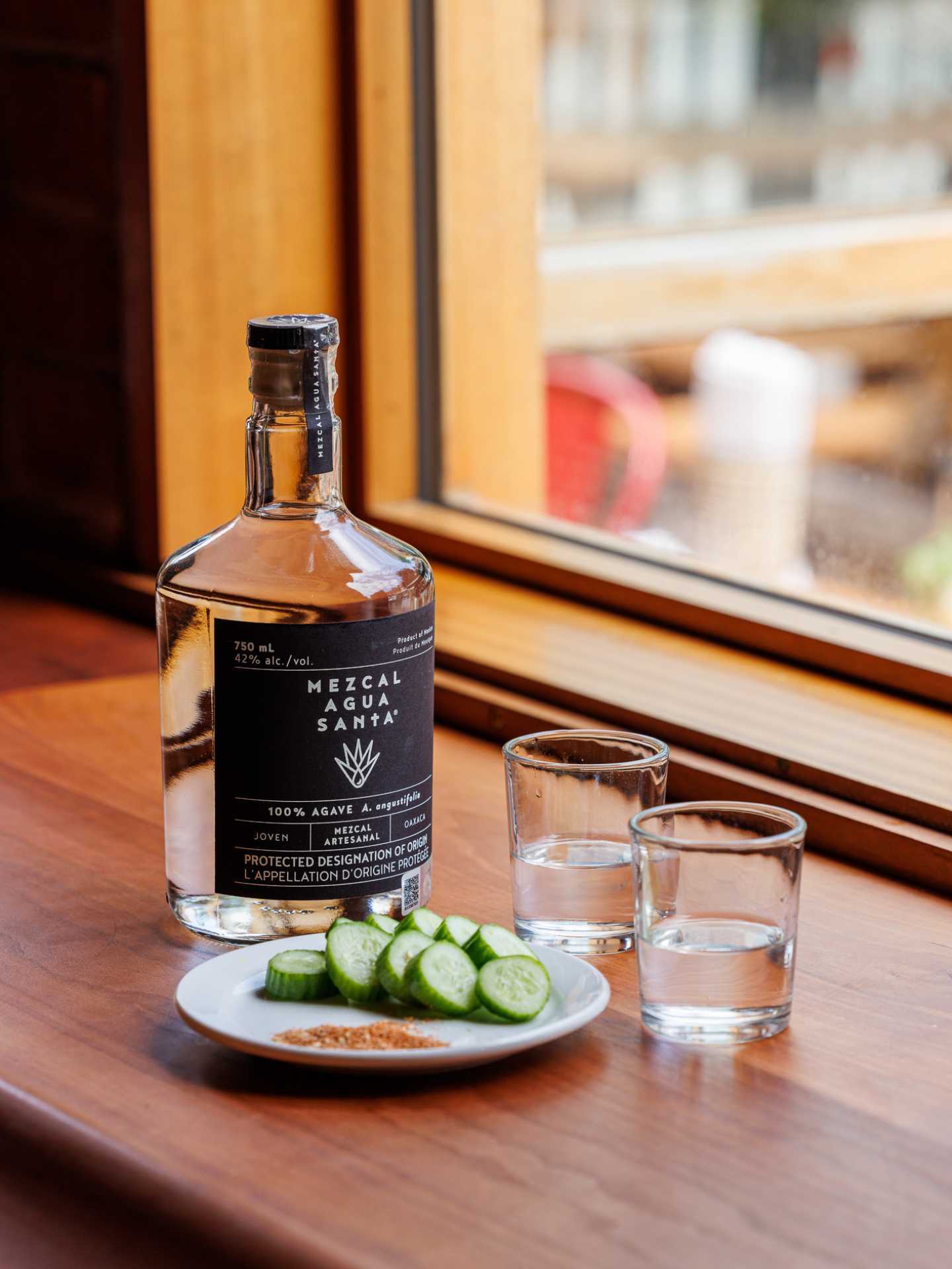 Tequila and mezcal | A bottle of mezcal on a table with cucumbers and rimming salt Tequila and mezcal | A bottle of mezcal on a table with cucumbers and rimming salt