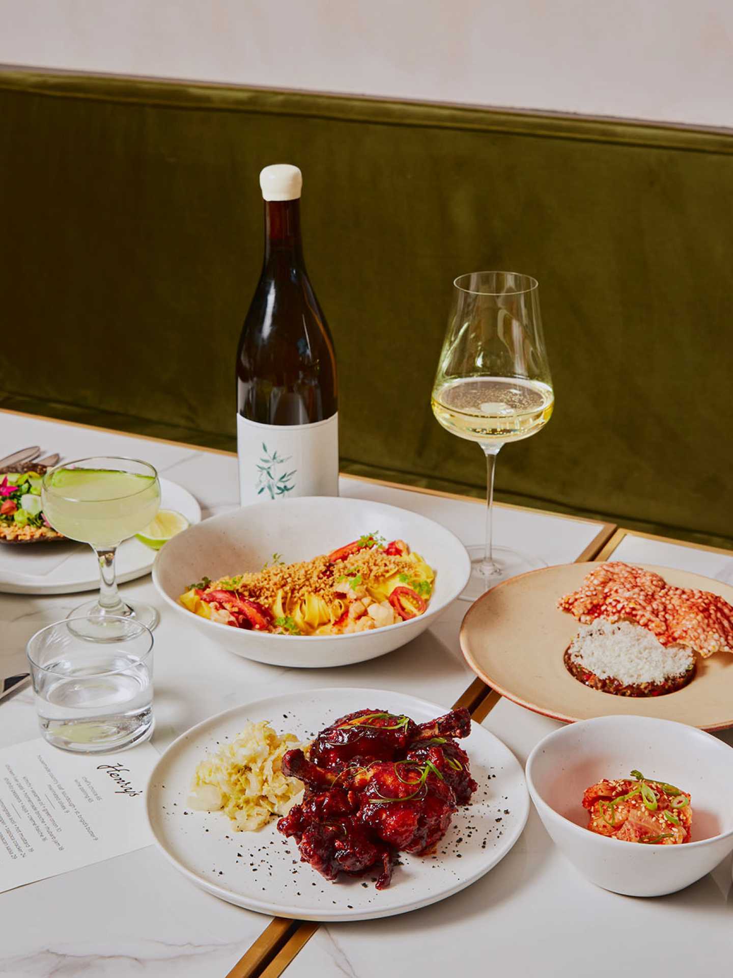 A spread of dishes, wine and a cocktail at Henry's restaurant Toronto