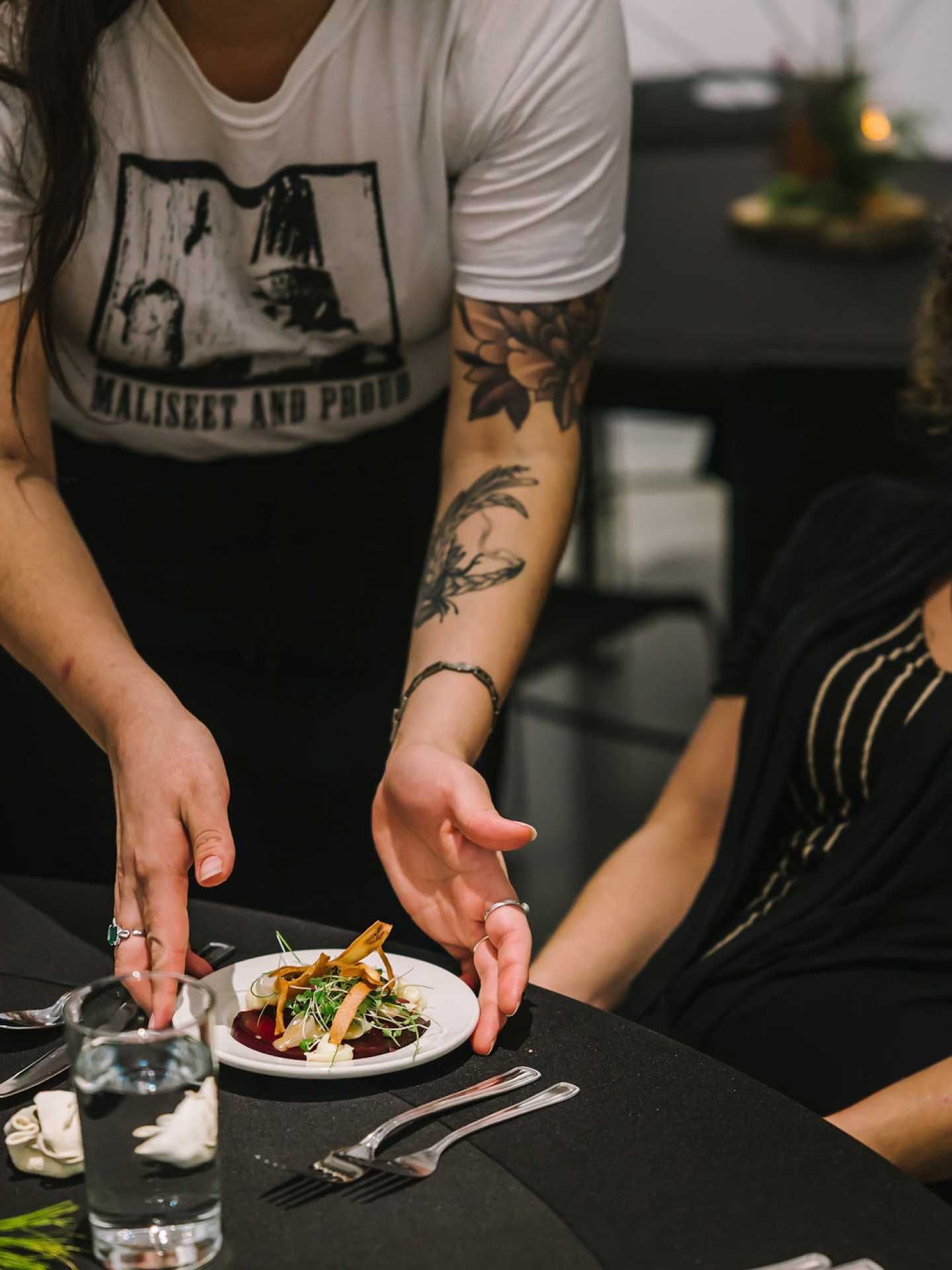 Indigenous food experiences in Canada | A server puts down a dish at A Taste of the Atlantic