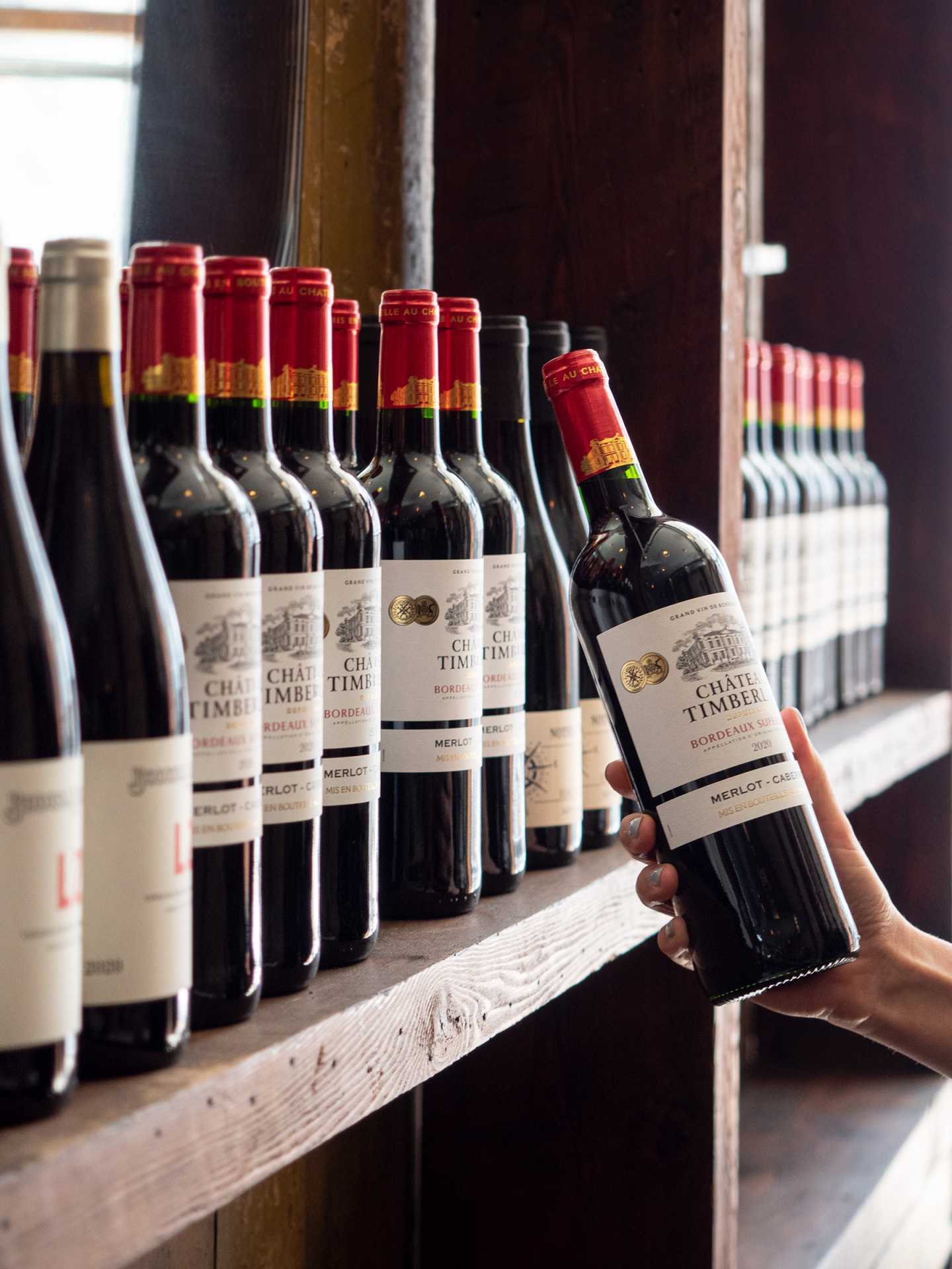 Best new Toronto restaurants | Pulling a wine bottle off the shelf at J's Steak Frites