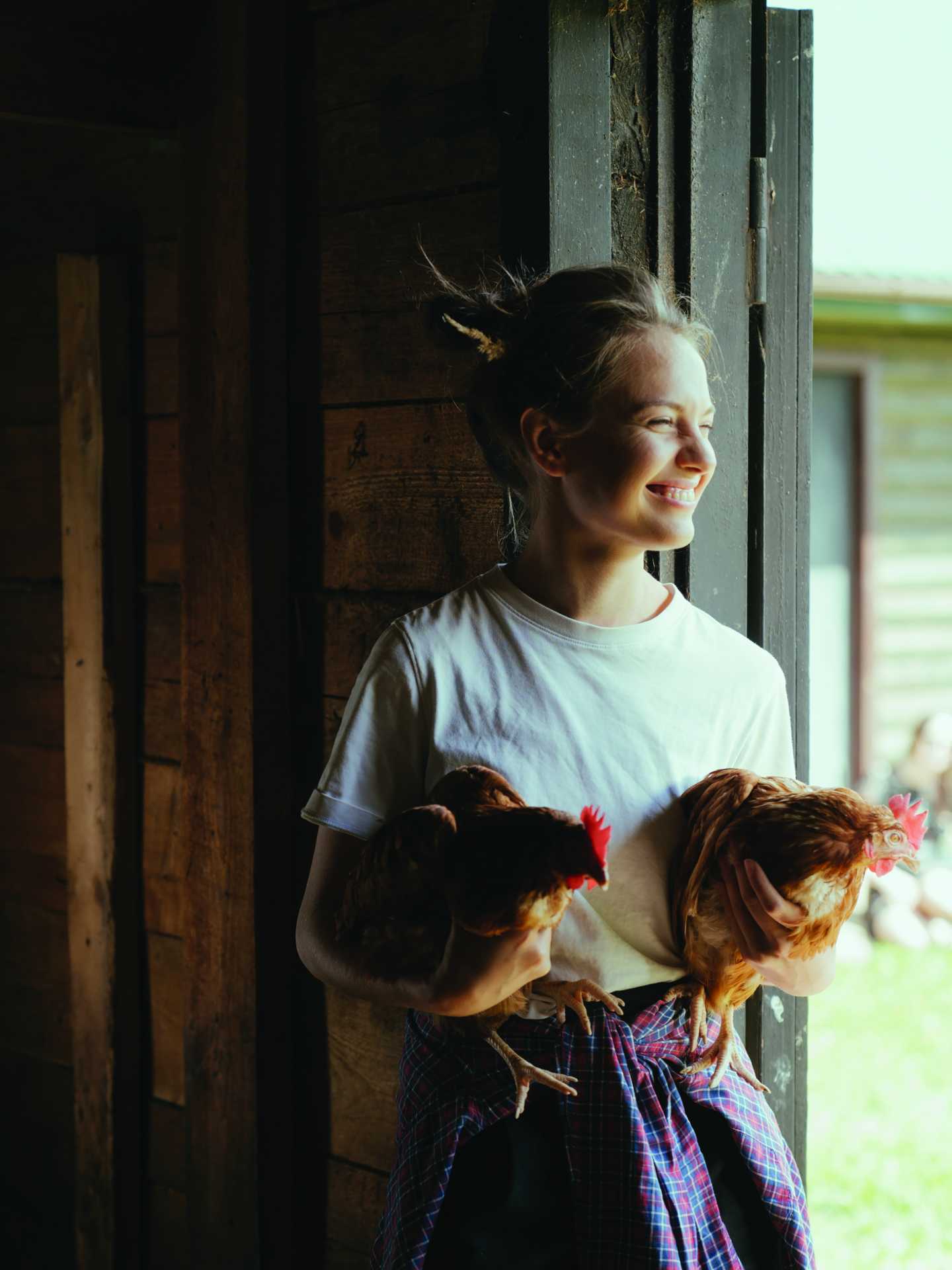 A woman holding two chickens A woman holding two chickens