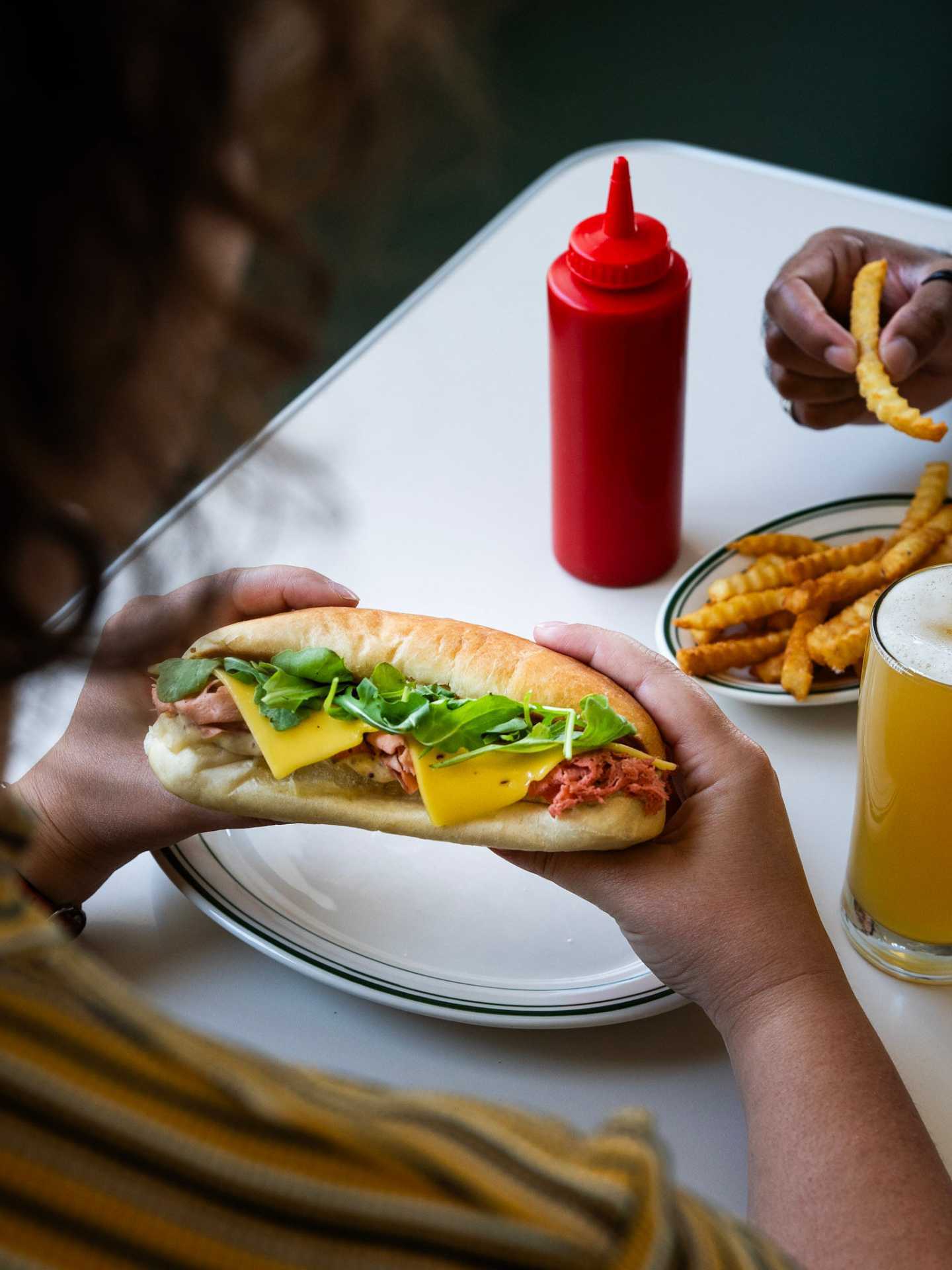 Best new restaurants Toronto | Someone holding a sub sandwich at Stefano's Diner in Toronto